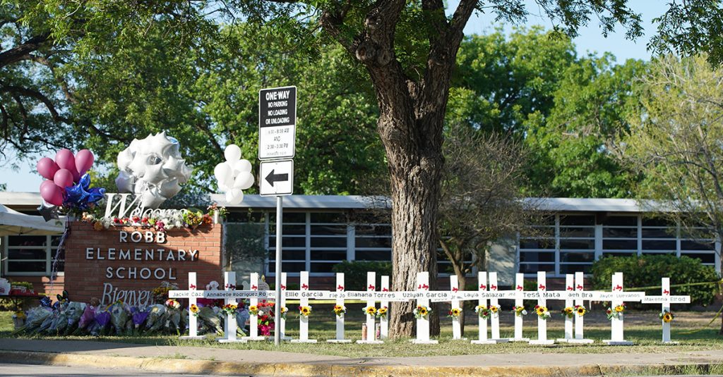 Memorial crosses and flowers outside Robb Elementary School in Uvalde, Texas, honoring victims of the 2022 shooting.