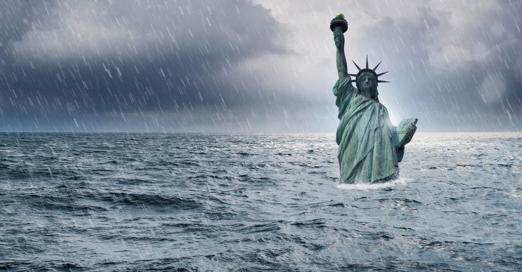 Statue of Liberty standing in a stormy ocean under heavy rain and dark clouds, symbolizing climate risk and national resilience.