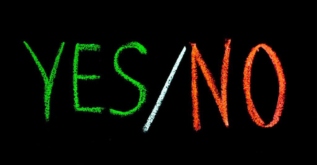 “YES/NO” written in chalk on a black background—YES in green, NO in red, with a white slash between.