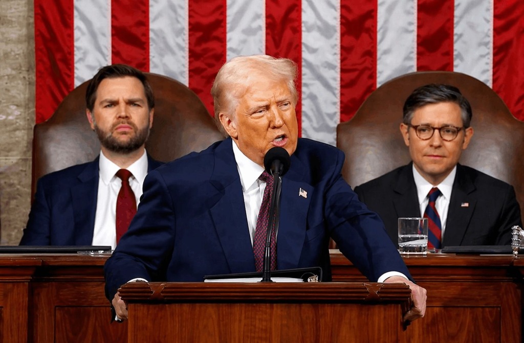 President Donald Trump delivers an address to Congress with lawmakers seated behind him and the American flag in the background