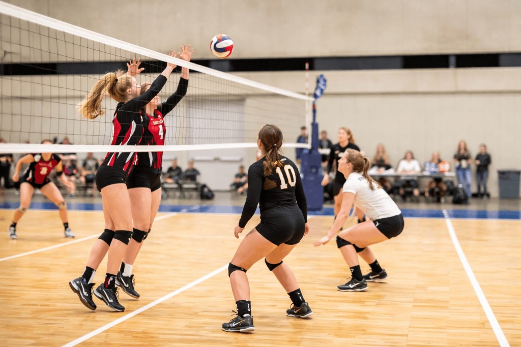 High school girls volleyball players competing at the net during a match