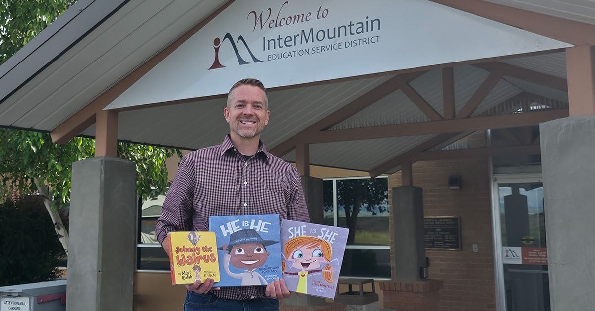 Christian social worker holds "Johnny the Walrus," "He is He," and "She is She," the three books Oregon education officials told him he couldn't display in his office.