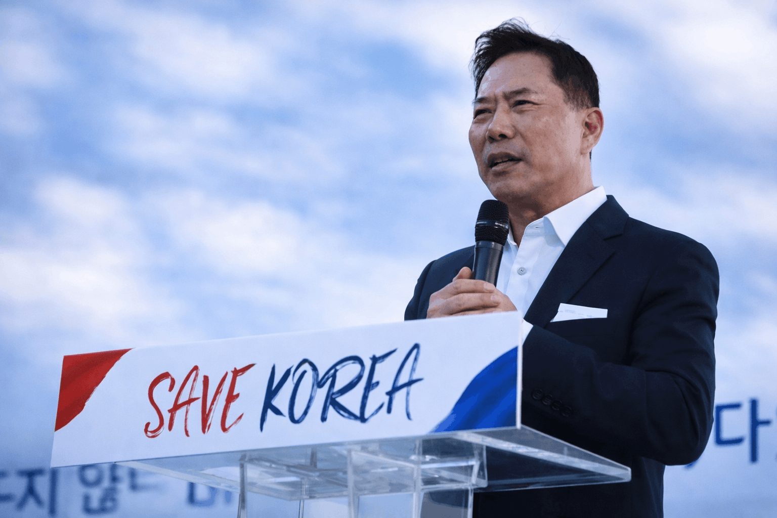 South Korean pastor speaking at a rally with “Save Korea” sign amid religious freedom concerns