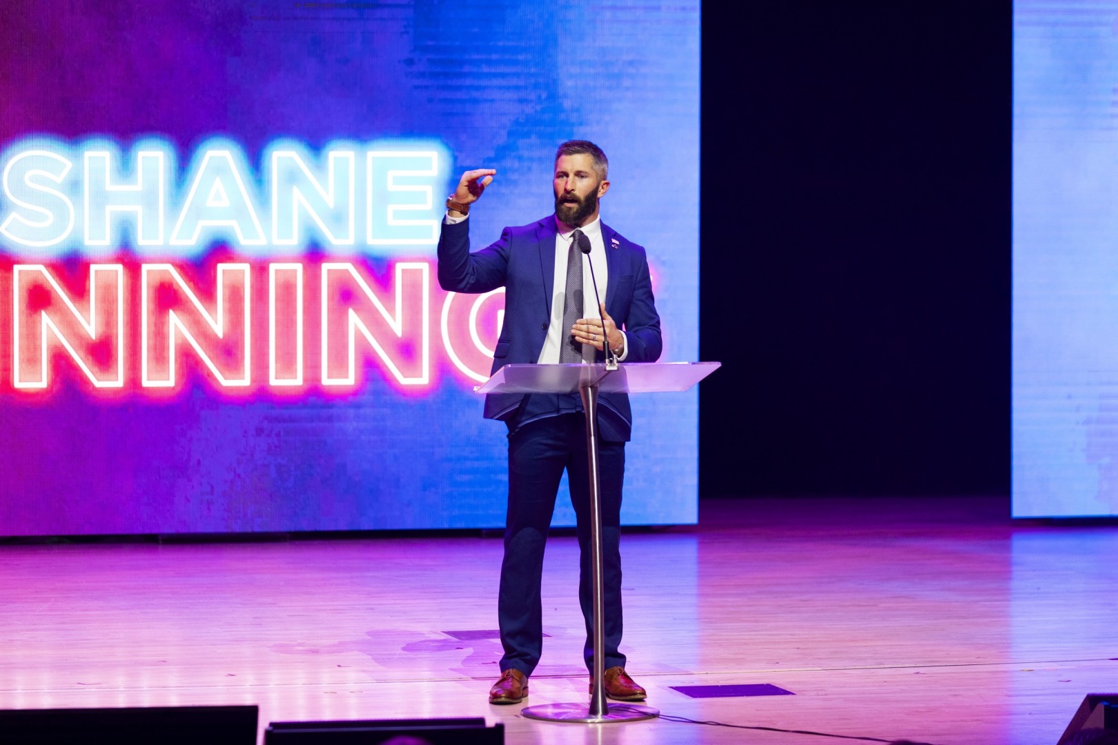 Shane Winnings making a “this high” gesture while speaking at the 2025 Freedom Uncensored event