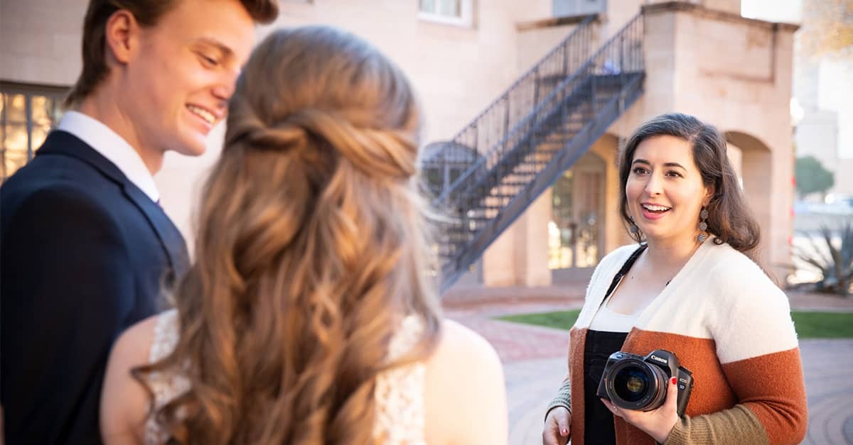 Wedding photographer Chelsey Nelson holds her camera as she speaks to a recently married couple during a photo shoot.