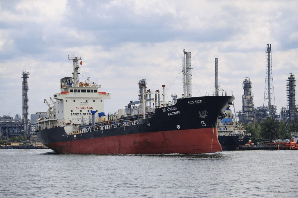 High-resolution image of a large oil tanker sailing past an industrial refinery in the Persian Gulf near Iran.