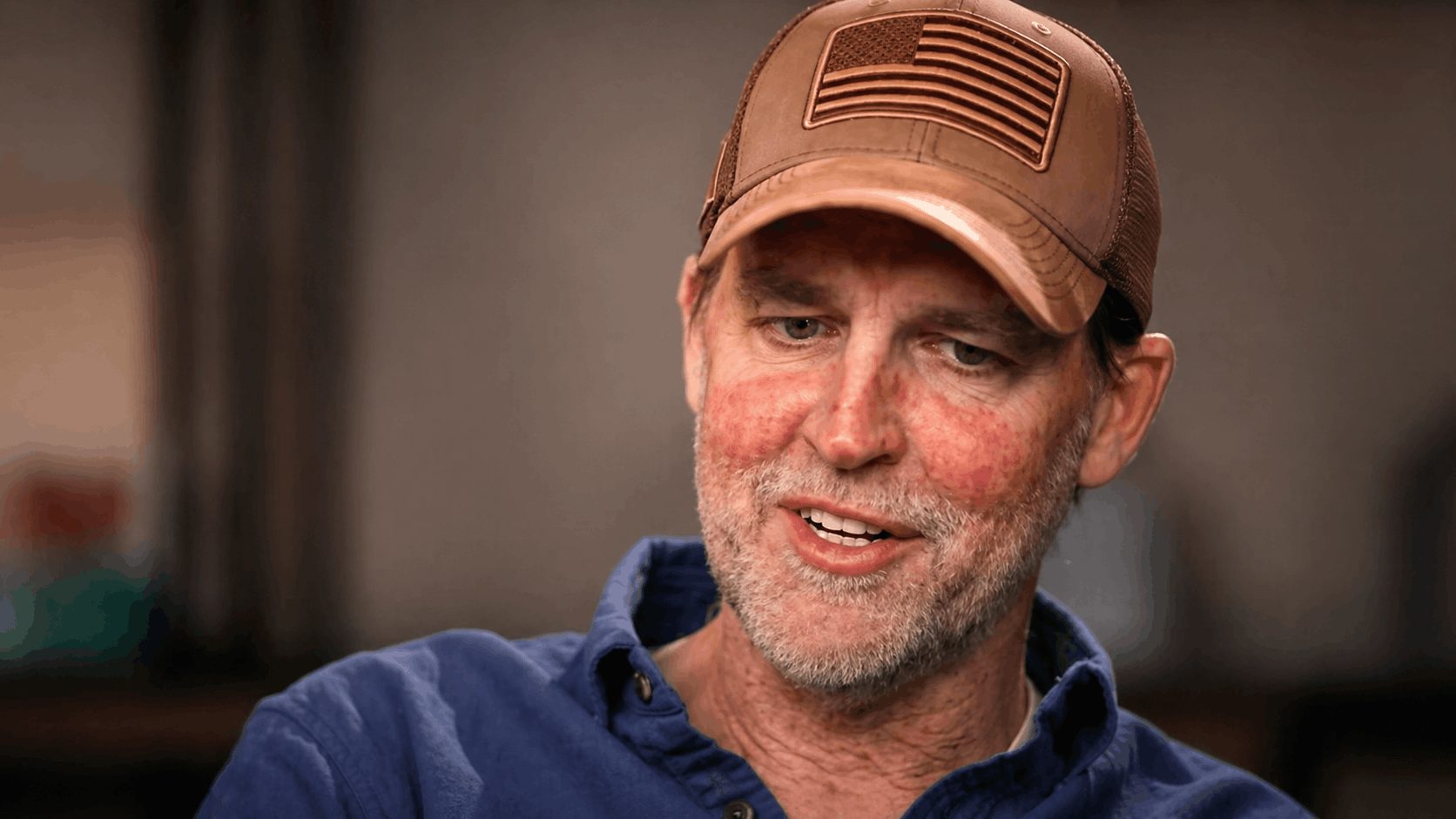 Former U.S. Sen. Ben Sasse, wearing a baseball hat with an American flag, speaks with 60 Minutes.