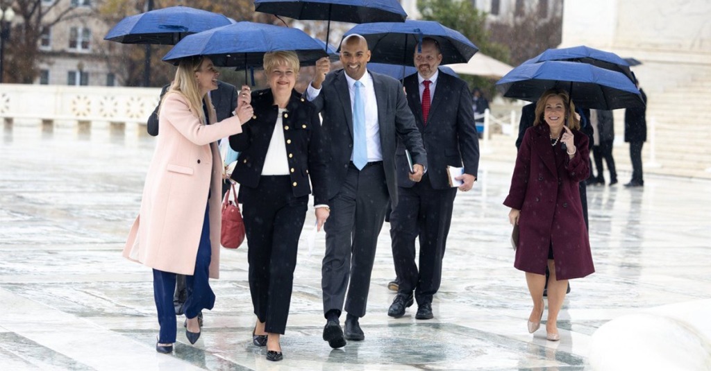 Aimee Huber (second from left), executive director of Women's Choice Health Resource Center, walking under umbrellas outside the U.S. Supreme Court, celebrating with her legal team after learning of the Supreme Court's unanimous ruling in her favor.