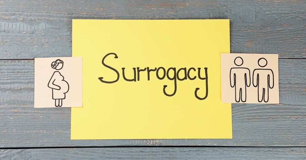 A sticky note with the word "Surrogacy" with notes showing stick figure drawings of a pregnant woman on one side and two men on the other.